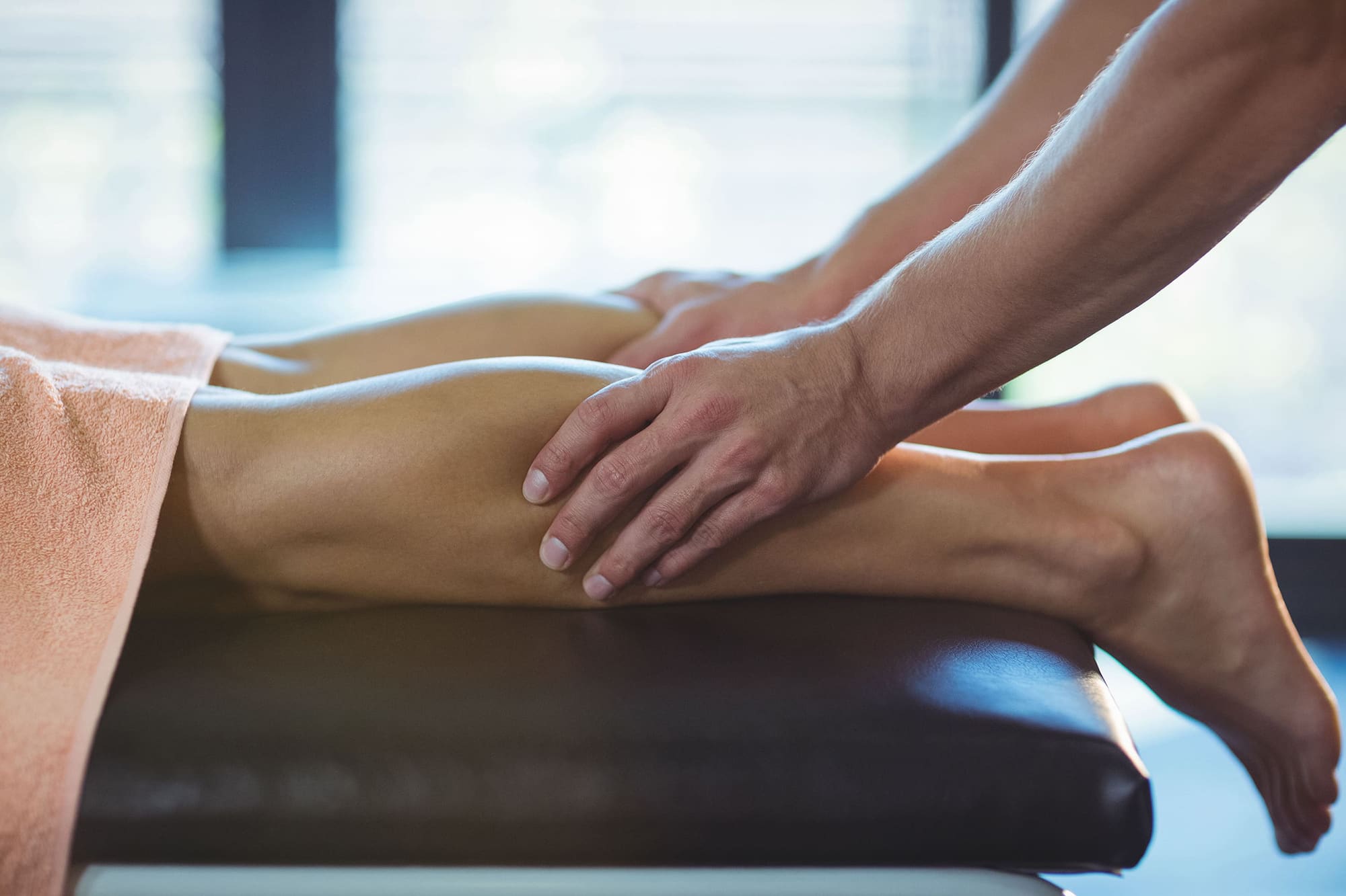 physiotherapist-giving-leg-massage-to-a-woman-BZZ38LK